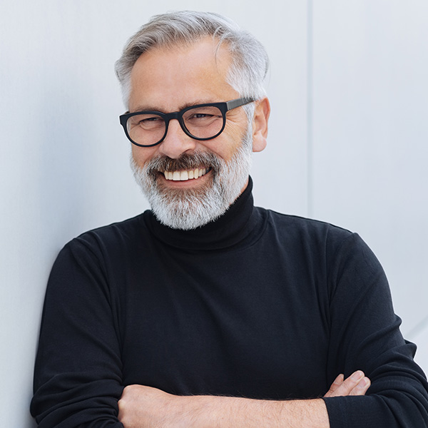 Happy man wearing glasses and smiling with beautiful teeth
