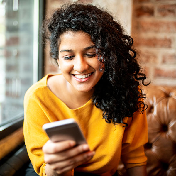 Happy woman smiling looking through her phone
