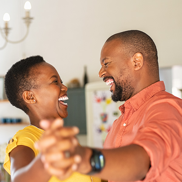 Happy couple dancing and smiling with beautiful teeth