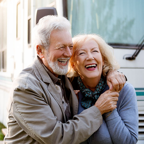 Happy couple smiling enjoying a road trip in a motor home
