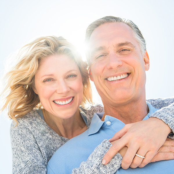 Happy elderly couple smiling with beautiful teeth
